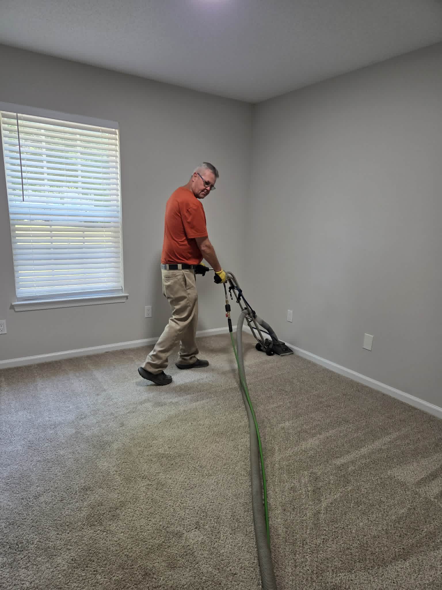 Carpet cleaning in progress with a hot-water extraction wand